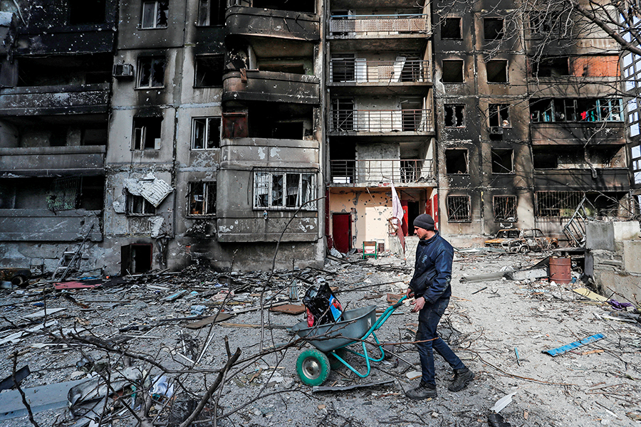 A local resident pushes a wheelbarrow in front of an apartment building destroyed during Ukraine-Russia conflict in the besieged southern port city of Mariupol, Ukraine March 30, 2022.
Image: Alexander Ermochenko / Reuters