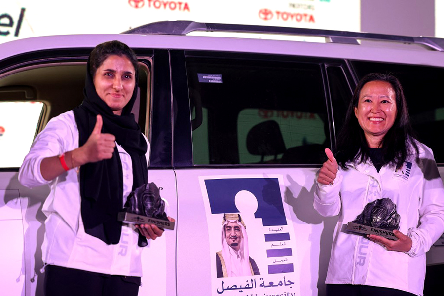 A picture taken on March 19, 2022 shows UAE's driver Atefa Saleh (L) and her co-driver US Eleana Coker celebrating after they won the second place in Rally Jameel, Saudi Arabiaís first ever women only motor rally, in Riyadh on March 19, 2022. (Photo by Fayez Nureldine / AFP)