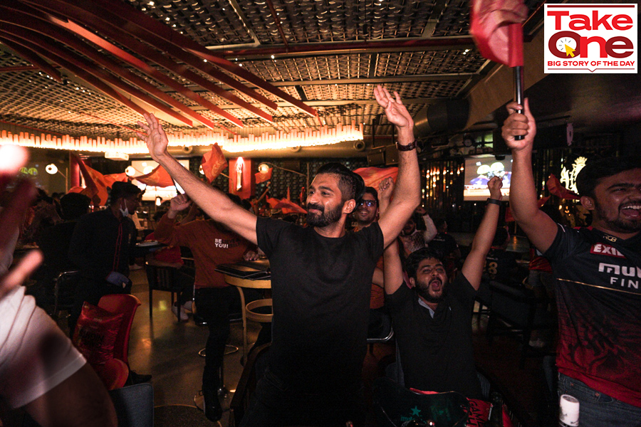 RCB fans cheer for the team at the RCB Bar & Cafe in Bengaluru. The sports cafe, launched in December 2020, was the IPL franchise's first foray into lifestyle