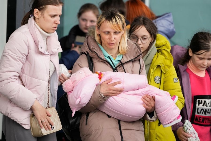 Refugee women with children walk to boarding transport at the central train station in Warsaw, Poland, Thursday, April 7, 2022. Image: AP Photo/Czarek Sokolowski 