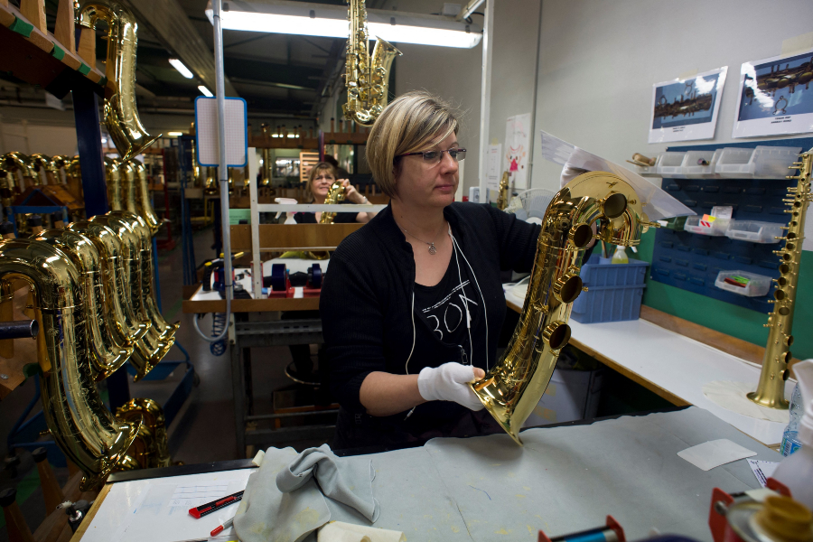 Employees work on polishing a saxophone piece, on January 17, 2018 at the Selmer Saxophone factory. Image: ALAIN JOCARD / AFP