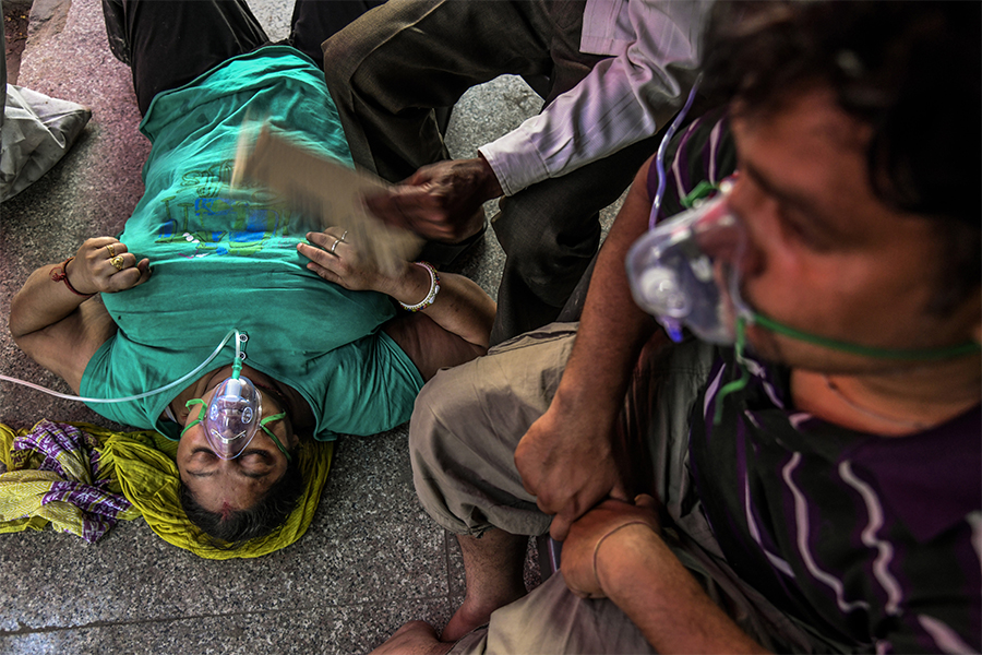 Covid patients receive oxygen provided by a Sikh house of worship on a street in New Delhi, April 25, 2021. The World Health Organization has calculated that 15 million people have died as a result of the pandemic, far more than earlier estimates, but the release of those numbers has been delayed for months because of objections from India, which disputes the calculation of how many of its citizens died. (Atul Loke/The New York Times)