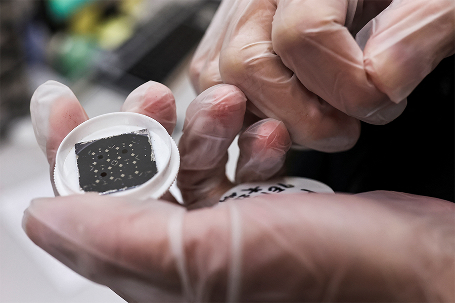 An engineer holds a chip in the middle of testing reactions from different materials and shapes that can have on the chip at the Taiwan Semiconductor Research Institute (TSRI) in Hsinchu. Image: Ann Wang/ Reuters