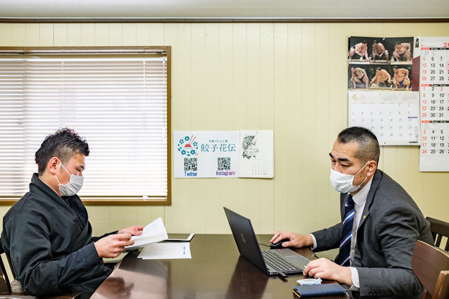 This picture taken on April 11, 2022 shows retired sumo wrestler Takuya Saito (R) talking with frozen dumplings factory and Chinese restaurant owner Tomohiko Yamaguchi (L) in Kyoto. (Credit: Philip FONG / AFP/Sumo-Japan-Retirement, FOCUS by Mathias CENA)

