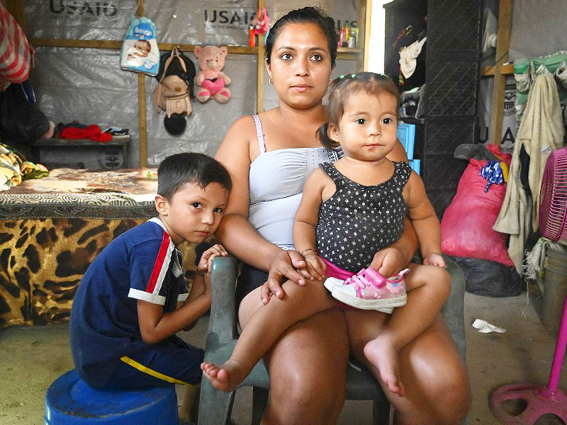 Sandra Ramos, 22, remains with her children Bryan and Zoy Yamileth Ramos, at an improvised shack she built with the help of the US Agency for the International Development (USAID) on the banks of the Ulua river after the passage of hurricanes Eta and Iota in La Lima, Honduras. Image: Orlando Sierra/ AFP