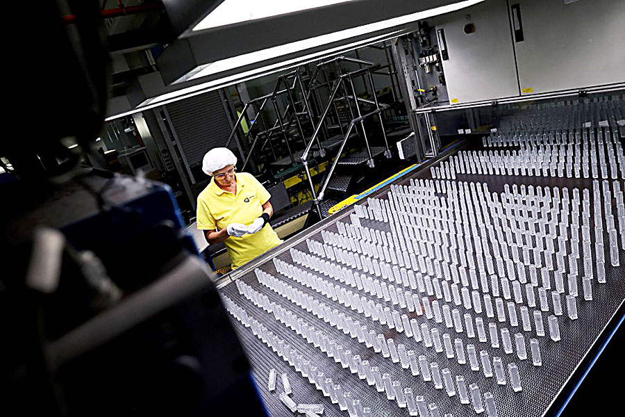 Quality controller Michaela Trebes inspects flacons on an assembly line at the German glass producer Heinz-Glas Group in Kleintettau, south Germany on August 3, 2022. Over 400 years, Heinz-Glas, one of the world's biggest producers of glass perfume bottles, has seen off crises from the plague to world wars. But Germany's current energy emergency strikes at the heart of its very existence. Image: Ronny Hartmann / AFP 