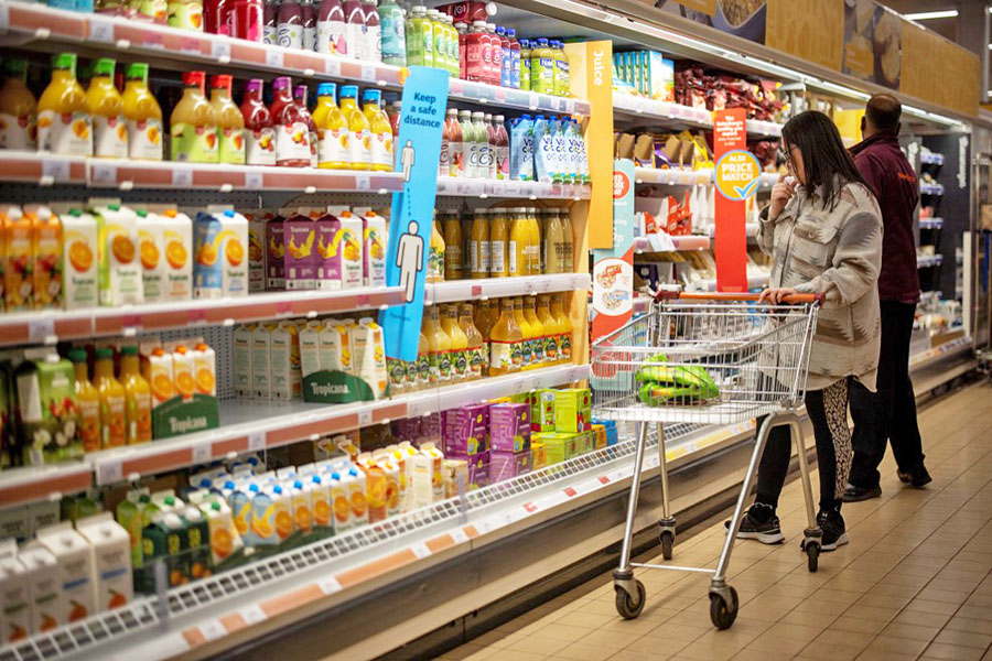 A customer shops for chilled fruit juice at a Sainsbury's supermarket in Walthamstow, East London. Image:Tolga Akmen / AFP