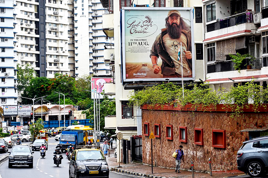 
Vehicles drive past a poster of the upcoming Bollywood film 'Laal Singh Chaddha' put up near a residential building in Mumbai on August 8, 2022. Image: AFP