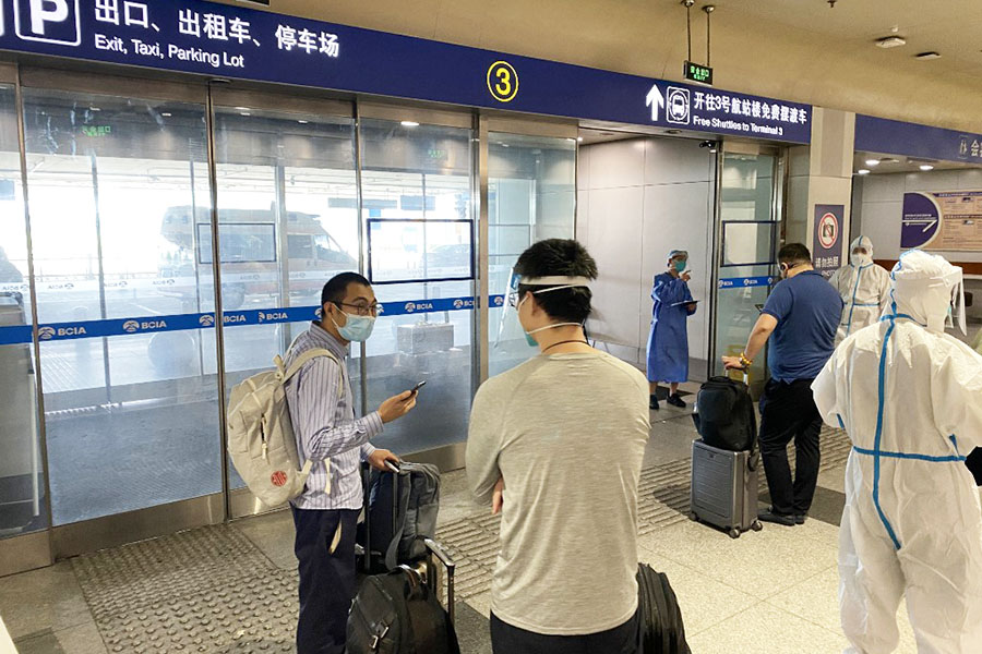 This photo taken on June 18, 2022, shows inbound passengers waiting to be taken to quarantine-designated destinations from the Beijing International Airport in Beijing. Image: Leo Ramirez/AFP 