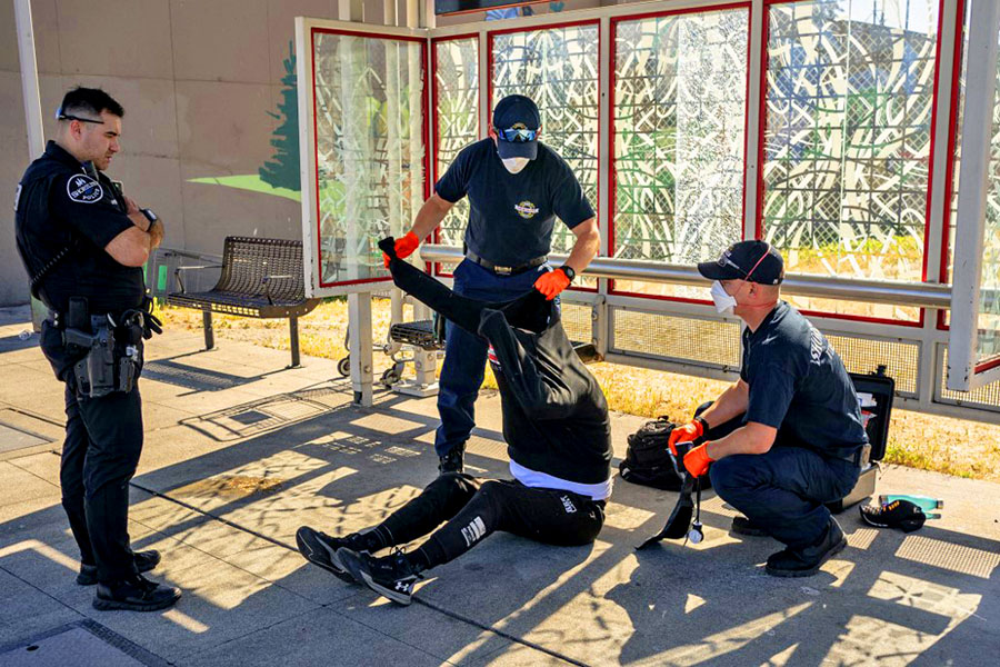 SHORELINE, WA - JULY 26: Ryan Horner and Owen Amos, firefighter EMTs with the Shoreline Fire Department, treat a homeless man showing symptoms of heat exhaustion on July 26, 2022 in Shoreline, Washington, United States. Image: David Ryder/Getty Images/AFP