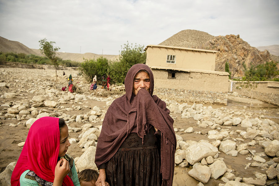 Residents after a flash flood that devastated several villages in Shinwari, eastern Afghanistan, on Aug. 17, 2022. Dilkhah, in her 60, break into tears, describing how she has lost everything she own after flash flood washed away her house. (Kiana Hayeri/The New York Times)