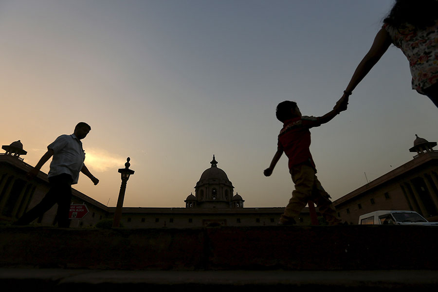 Commuters walk past the building of India's Ministry of Finance during dusk in New Delhi, India. Image: Adnan Abidi/ Reuters