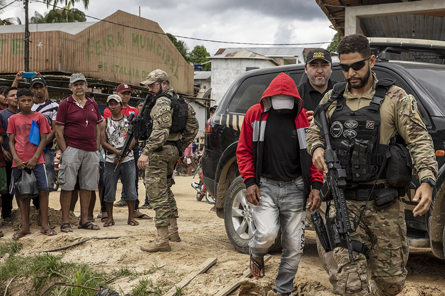 Police escort Amarildo Oliveira, who confessed to killing Bruno Pereira and Dom Phillips, in Atalaia do Norte, Brazil, June 15, 2022. The murders of Pereira, who wanted to protect the Amazon and its Indigenous people, and Phillips, who wanted to show how Indigenous communities were trying to defend themselves from poachers, is the story of two men killed while pursuing their passions. (Victor Moriyama/The New York Times)