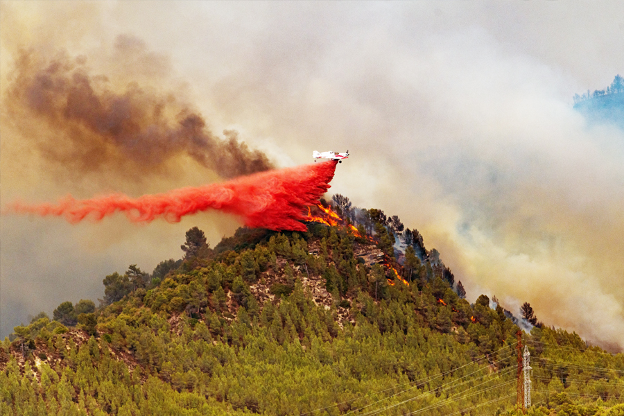 A seaplane unloads retardant on the flames of a forest fire on July 17, 2022, in Castellgali, Barcelona, Catalonia, Spain. The fire started today Sunday at noon and already affects 95 hectares, and 81 firefighting teams of the Bombers de la Generalitat are working to extinguish it, of which 13 are aerial. Image: Lorena Sopena/Europa Press via Getty Images
