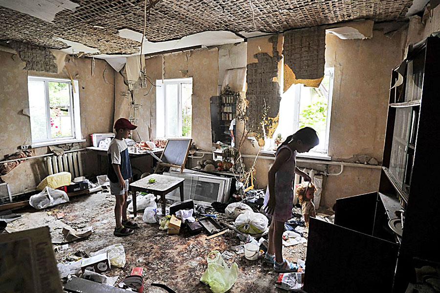 Children inspect a room damaged by the shelling in the town of Borodianka, near Kyiv on July 7, 2022. Image: Sergei Chuzavkov / AFP

