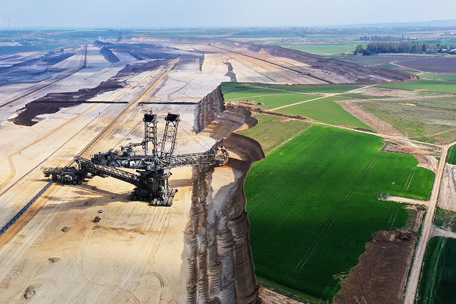 In this aerial view a bucket excavator removes top layers of soil and sand from former farmland during expansion of the Garzweiler II open-cast lignite coal mine on April 22, 2022 near Erkelenz, Germany. Garzweiler supplies the nearby Neurath coal-fired power station, which, according to data from 2020, is Europe's second biggest emitter of CO2. Image: Sean Gallup/Getty Images

