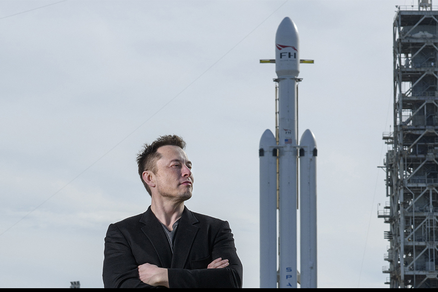 Elon Musk poses with the SpaceX Falcon Heavy rocket, at NASA's Kennedy Space Center in Cape Canaveral, Fla., Feb. 5, 2018. In emails to workers at SpaceX and Tesla, Musk said workers were required to spend a minimum of 40 hours a week in the office. (Todd Anderson/The New York Times)