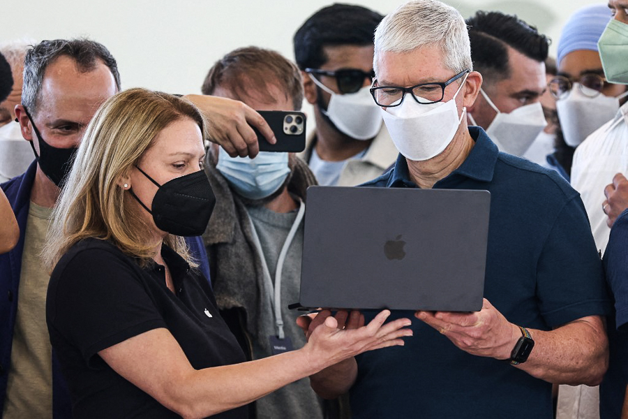 Apple CEO Tim Cook (R) looks at a newly redesigned MacBook Air laptop during the WWDC22 at Apple Park on June 06, 2022 in Cupertino, California. Apple CEO Tim Cook kicked off the annual WWDC22 developer conference. (Credits: Justin Sullivan/Getty Images via AFP)