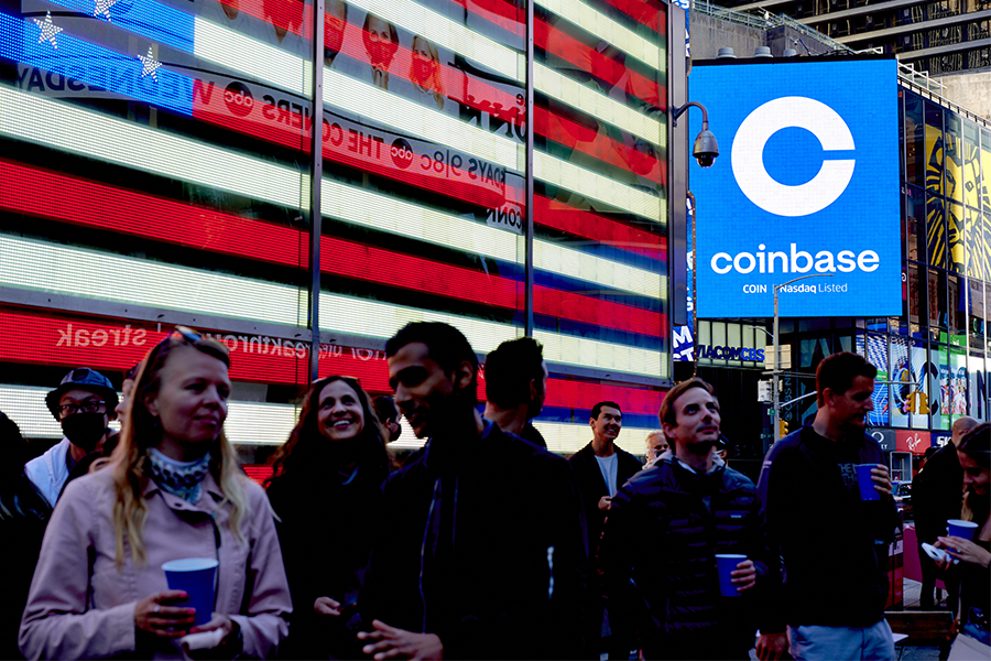 Coinbase employees gather in Times Square to see the launch of the company’s initial public offering displayed on the Nasdaq tower, April 14, 2021. Crypto companies are laying off staff, freezing withdrawals and trying to stem losses, raising questions about the health of the ecosystem. (Gabby Jones/The New York Times)