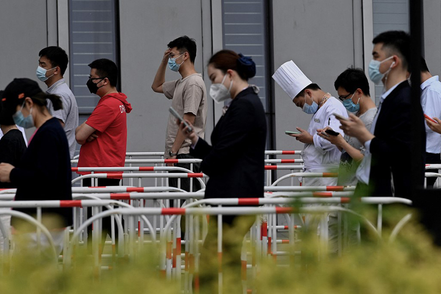 People queue to be tested for the Covid-19 coronavirus at a swab collection site in Beijing on June 13, 2022. Beijing on June 13 launched mass testing in its most populous district and delayed most school reopenings, as residents' precarious return to normal life is threatened by a rapidly expanding outbreak. Image: Noel Celis / AFP

