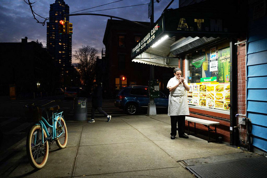 A file photo of a deli worker lighting up a cigarette outside a bodega in Brooklyn, New York on December 10, 2021.