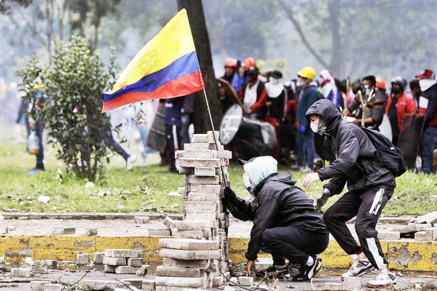 Demonstrators stand behind a barricade during clashes with riot police at the El Ejido park, in Quito, on June 24, 2022, in the framework of indigenous-led protests against the government. Ecuador's government and Indigenous protesters accused each other of intransigence as thousands gathered for a 12th day of a fuel price revolt that has claimed six lives and injured dozens. After the most violent day of the campaign so far—with police firing tear gas to disperse thousands storming Congress—the government accused protesters of shunning a peaceful outcome. Image: Cristina Vega RHOR / AFP