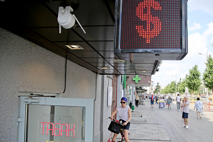 A woman pictured by a U.S. dollar sign at the entrance to the exchange office on June 27, 2022, in Moscow, Russia. Russia has defaulted on its foreign debt for the first time in over a century, after a grace period on missed interest payments expired on Sunday. Image: Contributor/Getty Images