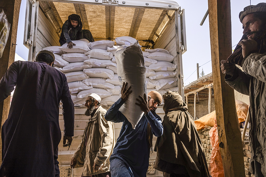 Laborers unload sacks of flour from a World Food Program convoy that traveled from Kabul to Afghanistan’s Tagab district, Oct. 27, 2021. Aid workers warn that a humanitarian crisis has already been exacerbated by the war in Ukraine, making it more difficult to feed the roughly 23 million Afghans — more than half the population — who do not have enough to eat. (Victor J. Blue/The New York Times)
