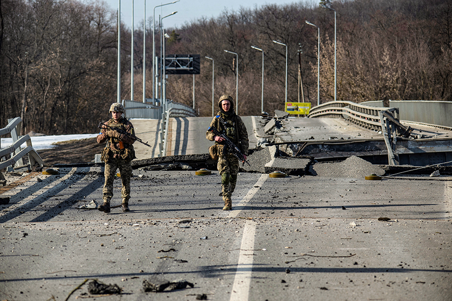 Ukrainian service members walk next to a destroyed bridge between the towns of Trostianets and Okhtyrka amid Russia's attack on Ukraine continues, in the Sumy region, Ukraine March 19, 2022. (Picture taken March 19, 2022) (Credit: Iryna Rybakova/Press service of the Ukrainian Ground Forces/Handout via REUTERS)