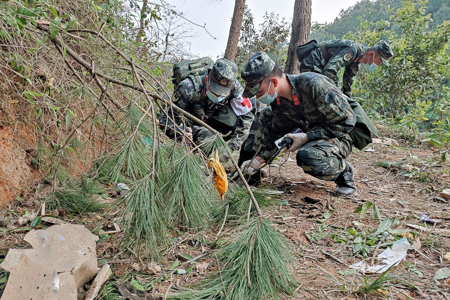 Paramilitary police officers conducting a search at the site of the China Eastern Airlines plane crash in Tengxian county, Wuzhou city, in China's southern Guangxi region. 
Image : CNS / AFP