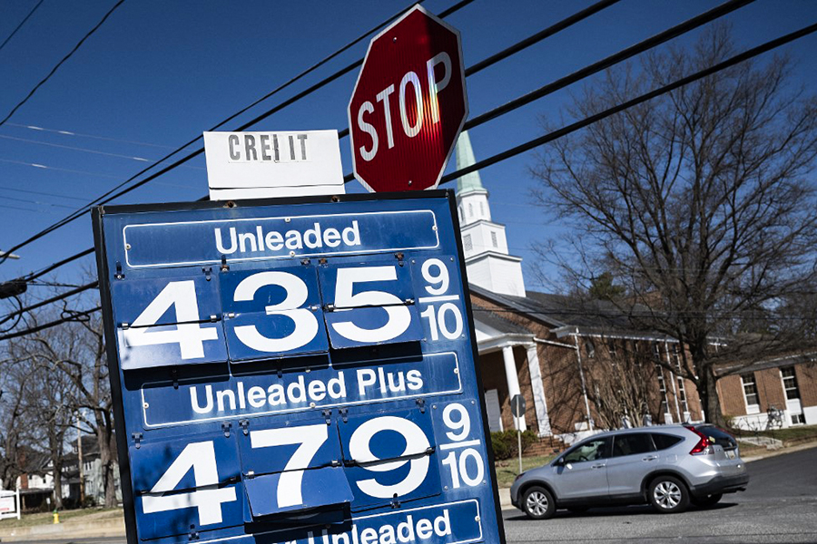 A car passes a gas station sign in Annapolis, Maryland, on March 14, 2022, as record high gas prices hit working class Americans with inflation already surging. (Photo by Jim WATSON / AFP)