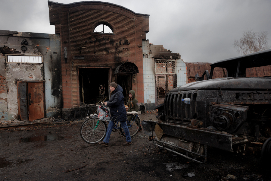 A resident walks past a burned out building after Ukrainian forces expelled Moscow's troops from the the town of Trostyanets which they had occupied at the beginning of their war with Ukraine, March 30, 2022. (Credit: Thomas Peter / Reuters)