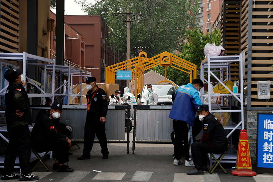 Security guards keep watch outside a residential compound under lockdown amid the coronavirus disease (COVID-19) outbreak in Beijing.​​ (Credits: REUTERS/Carlos Garcia Rawlins)