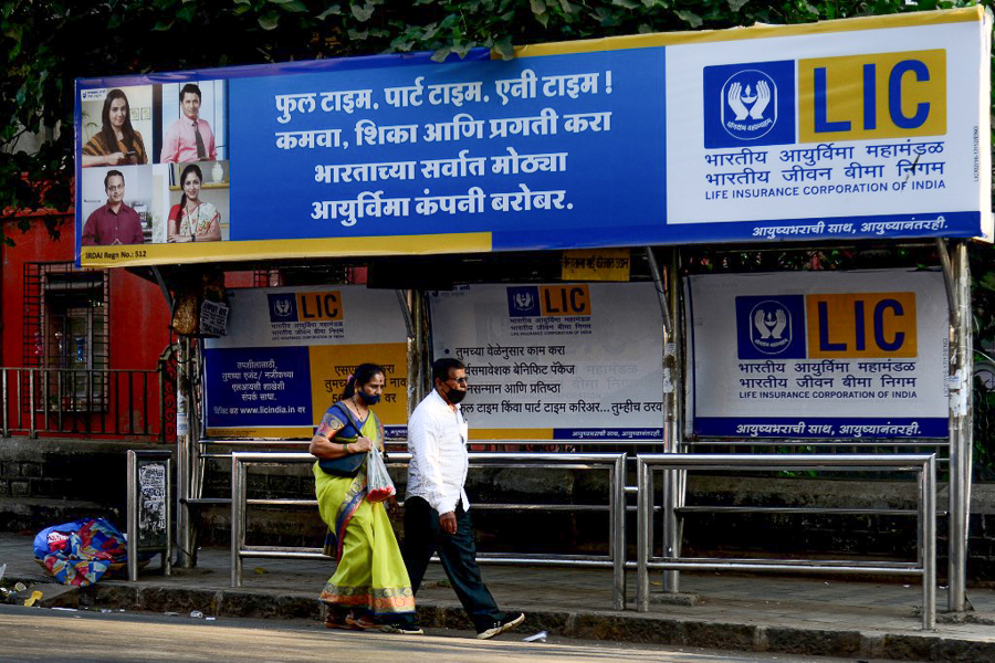 People walk past a bus shelter showing advertisement of country's largest insurer public, Life Insurance Corporation of India (LIC) in Mumbai
Image: Sujit Jaiswal / AFP