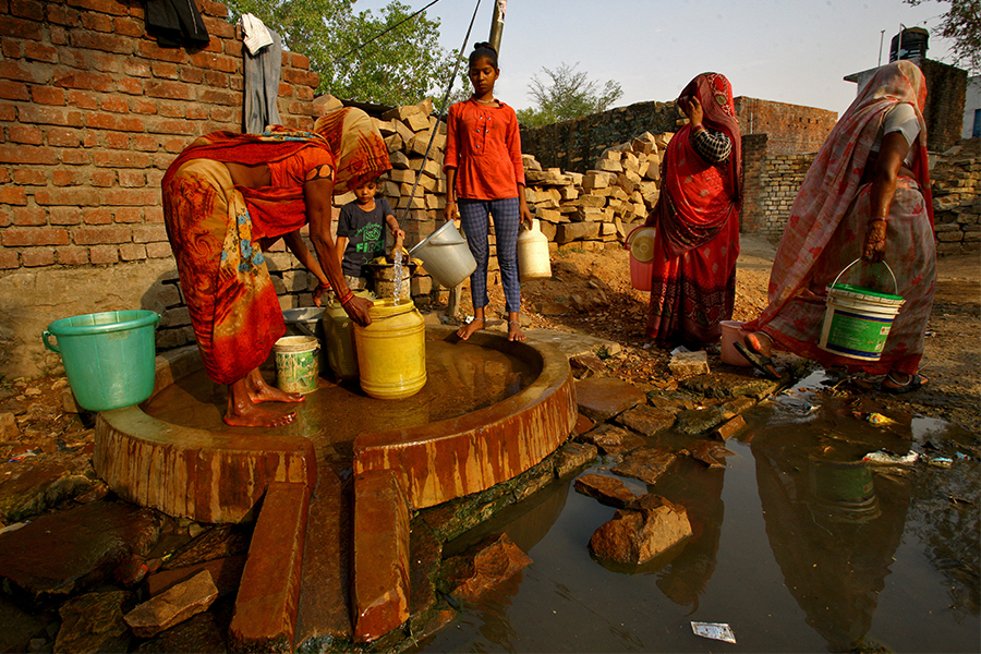 A woman fills a container with water at a municipal water pump on a hot day in Hinauti village in the northern state of Uttar Pradesh, India, May 4, 2022. Picture taken May 4, 2022. Image: REUTERS/Ritesh Shukla