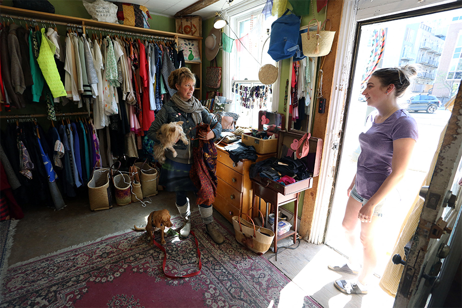 Adorit Boutique owner Emma Inns (L) speaks to a customer on May 5, 2022 in Ottawa, Canada. According to a recent Leger survey for PetSafe, 51 percent of Canadians support bringing dogs to the office. (Credits: Dave Chan / AFP)