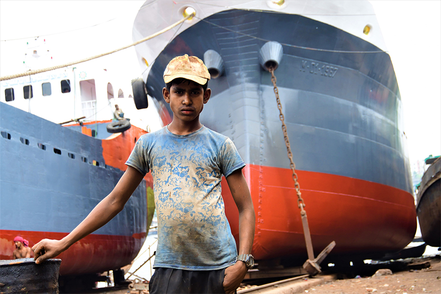 Alamin, 12, whose family lost their home to climate change-driven erosion, works as part of a shipbreaking crew in Keraniganj, close to Dhaka, Bangladesh, March 22, 2022. Image: Thomson Reuters Foundation/Mosabber Hossain