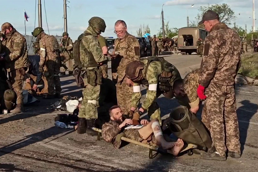 This screen grab obtained from a handout video released by the Russian Defence Ministry on May 17, 2022, shows Ukrainian service members as they are searched by pro-Russian military personnel after leaving the besieged Azovstal steel plant in Ukraine's port city of Mariupol.​ (Credits: Handout / Russian Defence Ministry / AFP)

