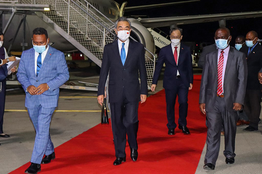 This picture taken on May 25, 2022, shows Solomon Island's Foreign Minister Jeremiah Manele (L) and Chief Protocole Walter Diamana (R) escorting Chinese Foreign Minister Wang Yi (C) upon his arrival at the Henderson International Airport in Honiara. Image: STRINGER / AFP