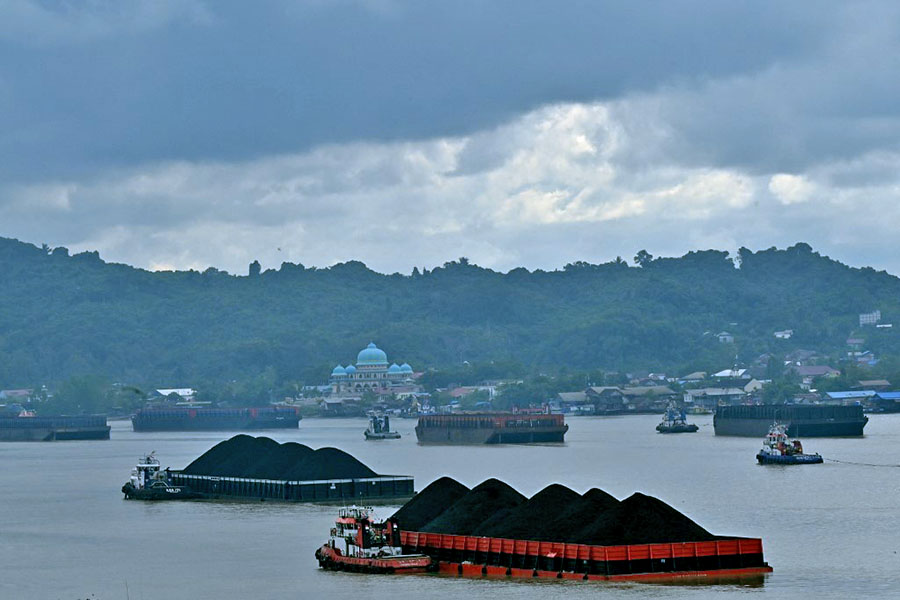 In this picture taken on August 16, 2022, piles of coal are seen on barges in Samarinda, East Kalimantan, Borneo. IEA called for international finance centres to channel funding and expertise more quickly to coal-dependent nations in order to accelerate their low-carbon transition. Image: Adek Berry/AFP 