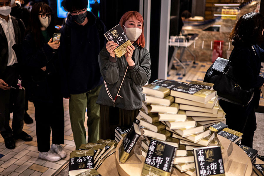 
People line up to purchase the fresh copies of Japanese writer Haruki Murakami's new novella 