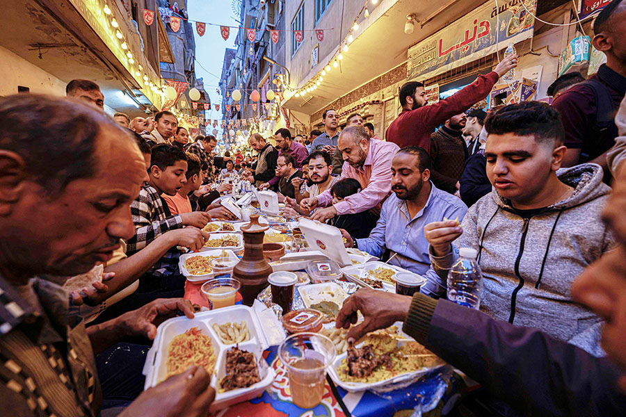 Egyptian Muslims gather in streets lined with long tables to break their Ramadan fast together in a mass 