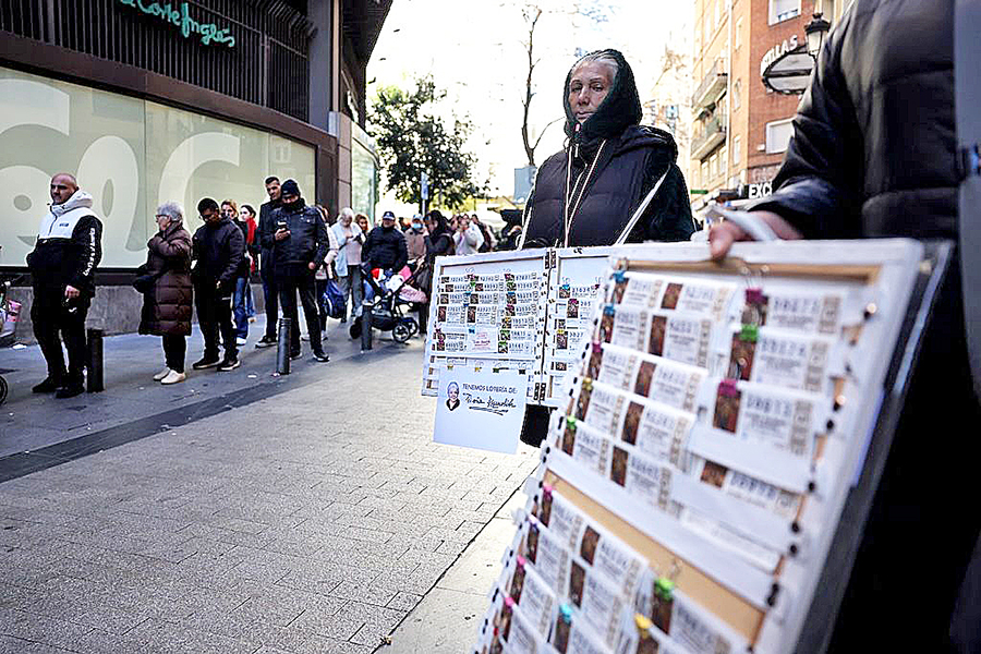 Street vendors stand as people queue to buy Christmas lottery tickets outside the popular lottery outlet 'Dona Manolita' on December 18, 2023 in central Madrid. Image: THOMAS COEX / AFP