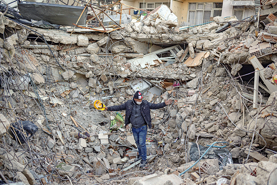  A man stands amid the rubble of a collapsed building while Greek and Turkish rescuers try to exhume the bodies in Antakya, south of Hatay, on February 15, 2023, nine days after a 7,8-magnitude struck the country's southeast. Image: Yasin AKGUL / AFP