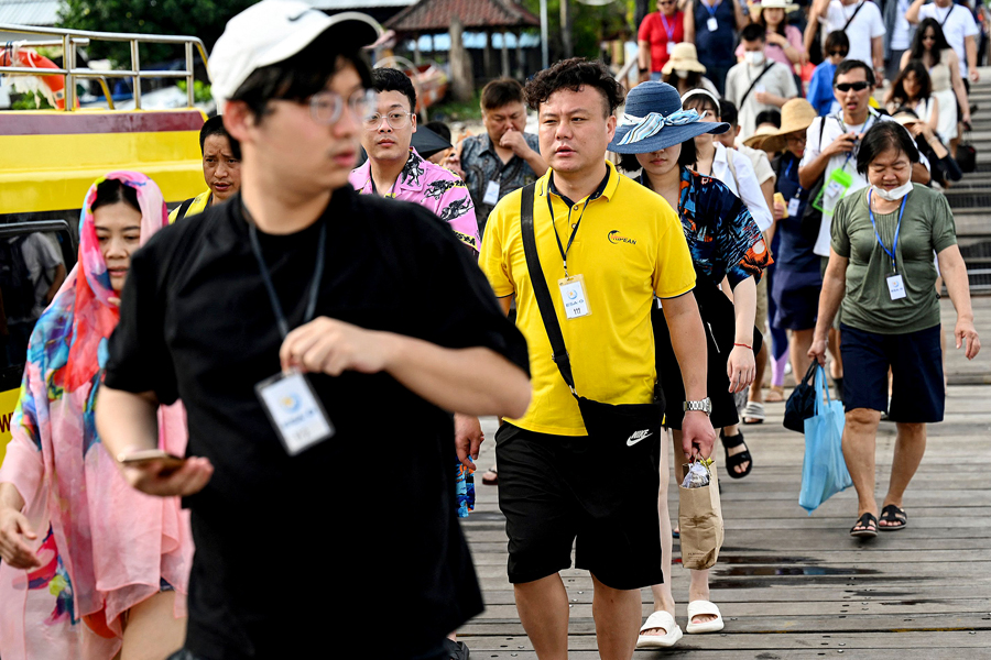 Chinese tourists prepare to board a fast boat for their trip from Serangan Island to Lombok Island in Denpasar, on Indonesia's resort island of Bali, on January 25, 2023.
Image: Sonny Tumbelaka/ AFP 