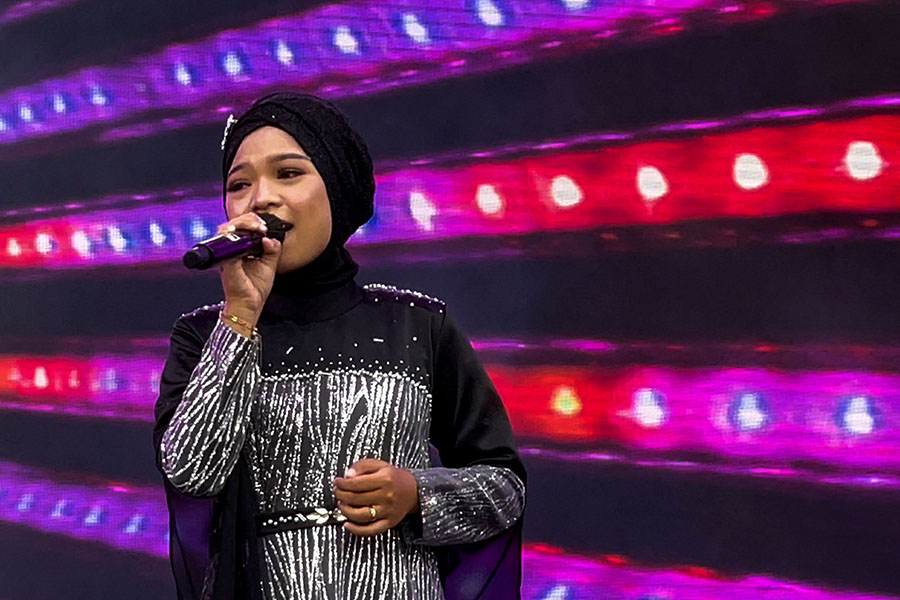 Makhi, a member of the all-female hijab-clad Nasida Ria band, performing on stage in front of an audience at a festival in Jakarta
Image: Agnes Anya / AFP 