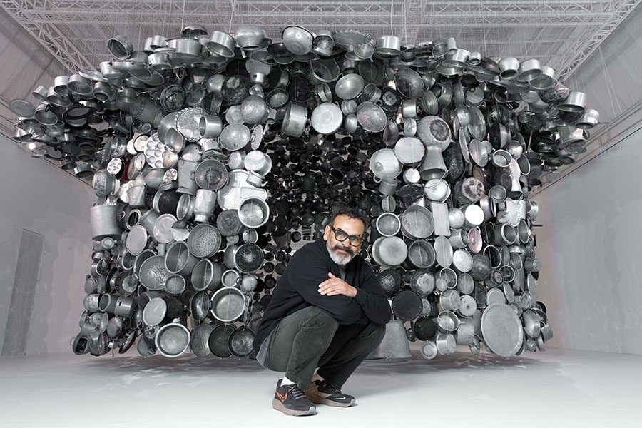 Indian artist Subodh Gupta poses in front of one of his installations.
Image: Joel Saget / AFP 