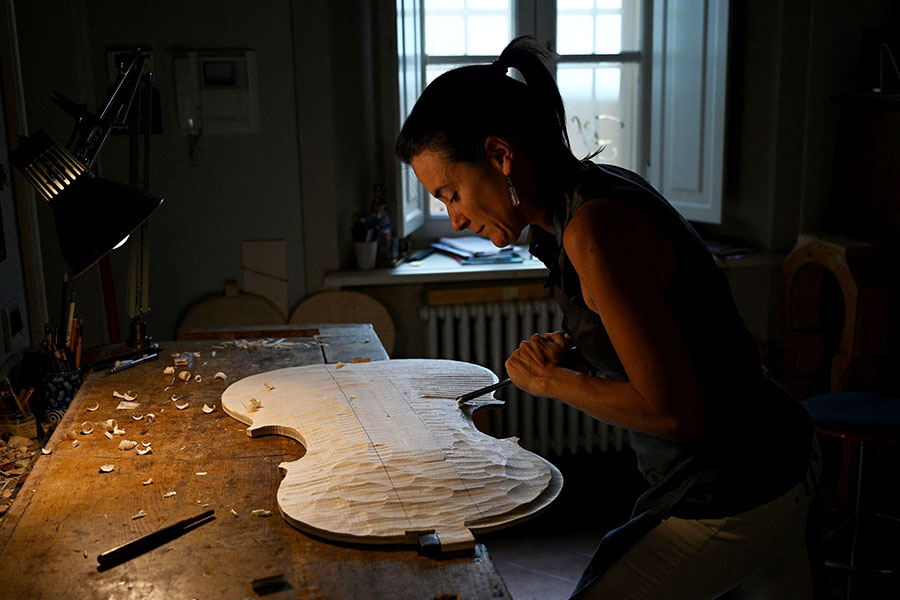 French violin maker Benedicte Friedmann works on the body of a violin in her Cremona workshop.
Image: Gabriel Bouys / AFP 