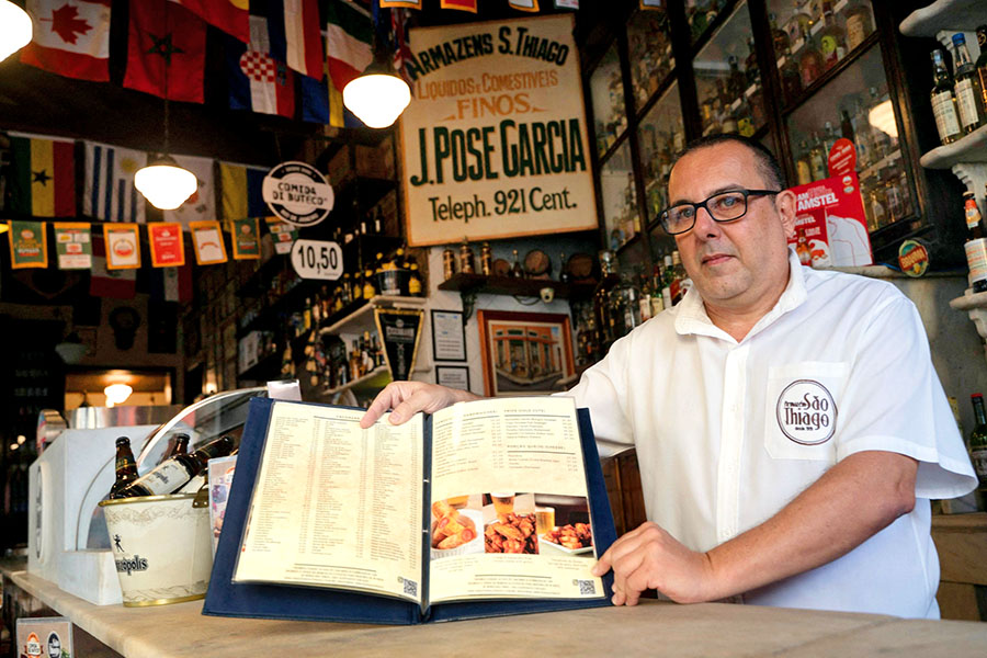 Carlos Fionda, 59, manager of Amazem Sao Thiago bar, shows their physical menu at the Lapa neighborhood in Rio de Janeiro.
Image: Mauro Pimentel / AFP 