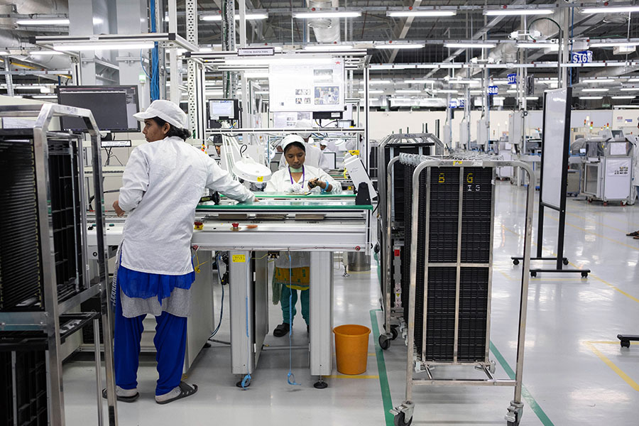 Employees work on an assembly line in the mobile phone plant of Rising Stars Mobile India Pvt., a unit of Foxconn Technology Co. in Sriperumbudur, Tamil Nadu, India; Image: Karen Dias/Bloomberg via Getty Images